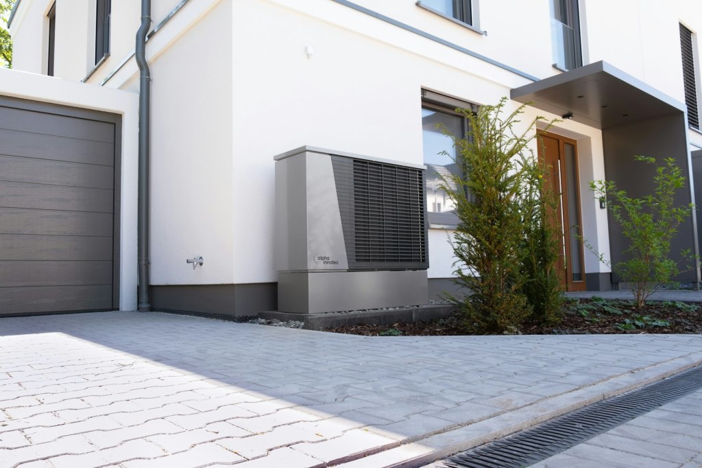 Modernes Einfamilienhaus mit Wärmepumpe vor der Fassade