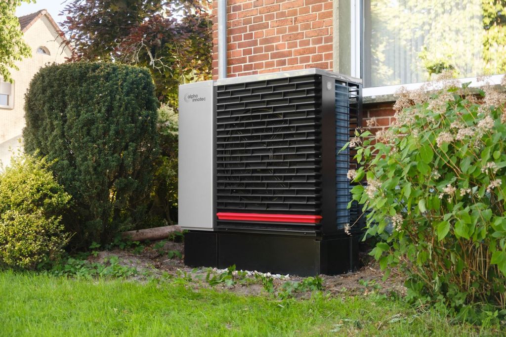 Wärmepumpe im Garten eines Wohnhauses